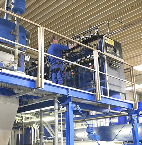 Mitarbeiter bei der Wartung einer Pulverbeschichtungsanlage