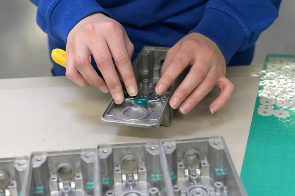 Nahaufnahme eines Metallteils, das zur Pulverbeschichtung vorbereitet wird